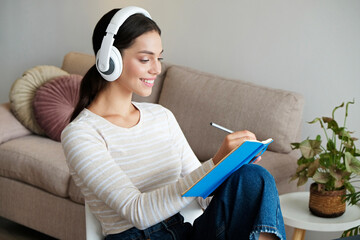 Online education concept. Young brunette woman wearing eyeglasses and headphones taking part in a...
