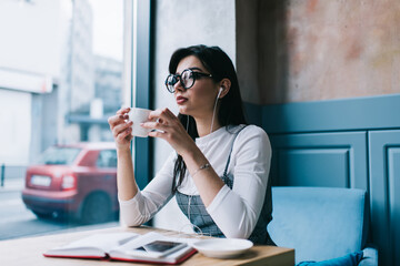 Thoughtful woman drinking coffee in cafe