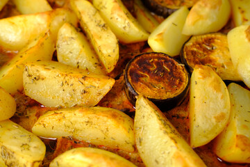 appetizing potatoes, eggplant slices baked in the oven, lying on a baking sheet, the concept of home cooking, traditional dishes