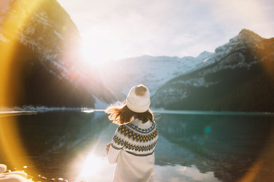Unrecognizable woman traveler against lake and mountains in morning
