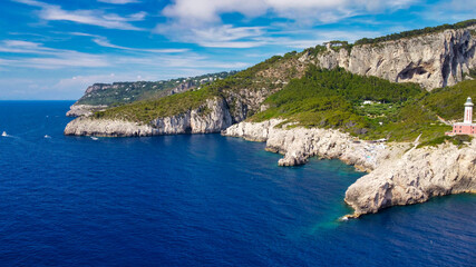 Fototapeta premium Lighthouse and Beach of Capri in summer season. View from a moving drone.