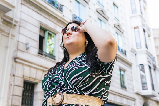Stylish woman in sunglasses on city street