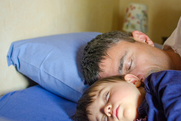 Obraz na płótnie Canvas Father and Daughter Sleeping together in the Bed