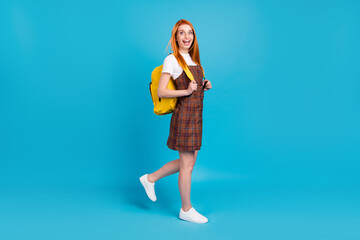 Fototapeta na wymiar Full length body size view of attractive cheerful nerd girl walking back to school having fun isolated over bright blue color background