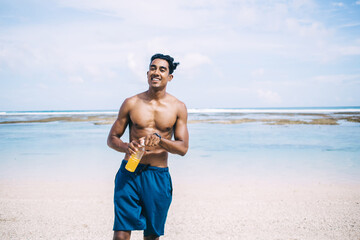 Satisfied male enjoying vitamin beverage on coastline