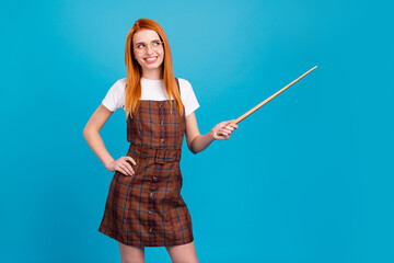 Photo of young girl happy positive smile lesson teacher indicate pointer empty space college isolated over blue color background