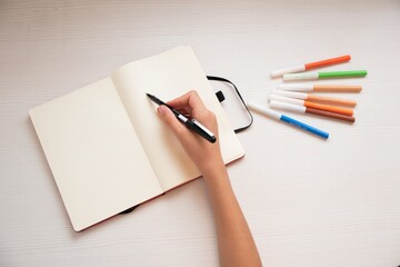 Niño escribiendo en una libreta en blanco