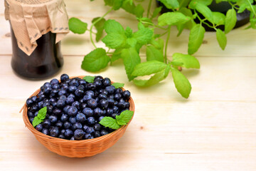 blueberries in a basket and a jar of jam and a place for an object