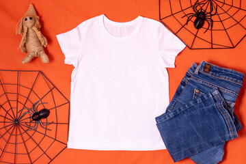 White t-shirt mockup with halloween spiderweb decor on orange halloween background