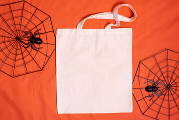 White tote bag canvas fabric. Cloth shopping sack mockup with copy space with spiderweb on orange...
