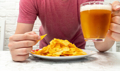 person with beer and potato chips