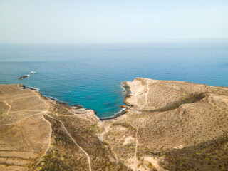 Tenerife, a town on the Atlantic Ocean. Sunny coast and dry soil. Ocean, water, waves, blue ocean.