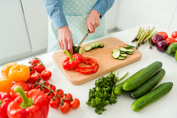 Cropped view of girl making meal chopping useful vegs vitamin menu salad recipe at home light white kitchen indoors