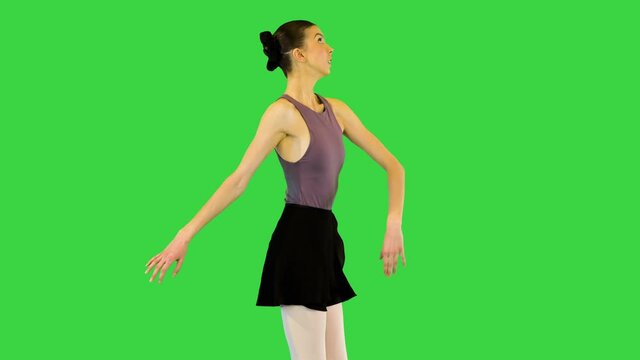 Young ballerina walks demi-pointe waving arms on a Green Screen, Chroma Key.