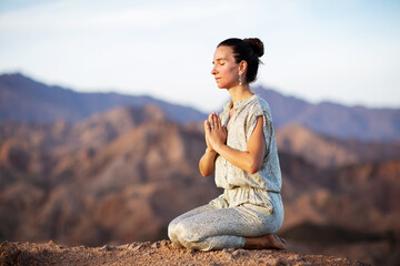 Fototapeta na wymiar Woman practicing yoga in the mountains in the desert