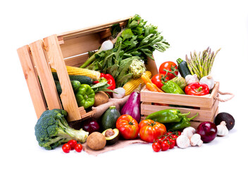 Wooden boxes full of fresh vegetables on a white background, ideal for a balanced diet