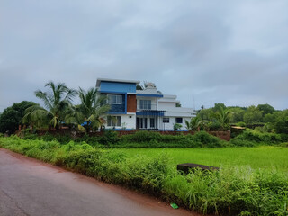 Fototapeta na wymiar KBeautiful shot of Kerala model modern architectural home exterior design surrounded by landscapes