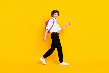 Fototapeta na wymiar Full size profile photo of cute little brunet boy go wear bag uniform shoes isolated on yellow background