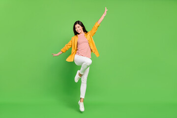 Fototapeta na wymiar Full size photo of cool brunette millennial lady jump wear shirt trousers isolated on green color background