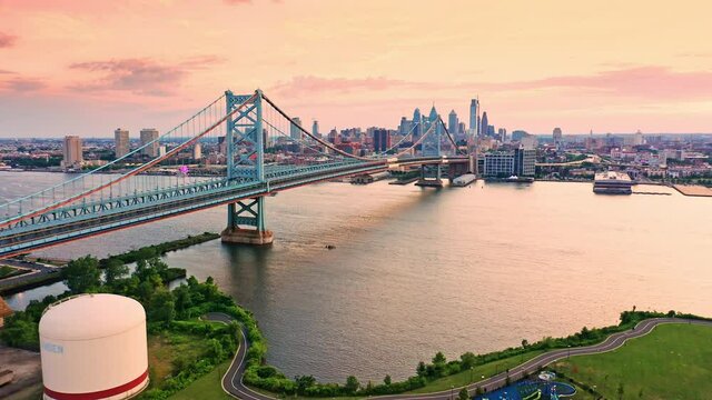 Aerial view Ben Franklin Bridge and Philadelphia skyline with slow camera lift up, at sunset. Ben Franklin Bridge is a suspension bridge connecting Philadelphia and Camden, NJ.