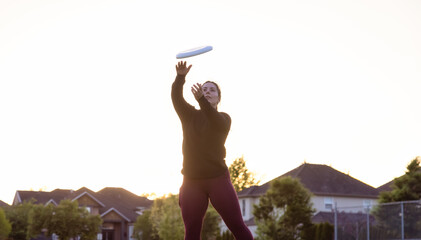 White Caucasian Adult Woman Playing Ultimate Frisbee in the Green Field at neighborhood city park....