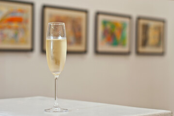 Glasses with wine on the background of the exhibition of paintings. Artwork blurred in the...