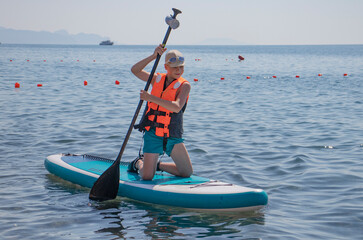 boy sailing on Sup board on the sea