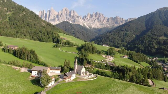 Flying over Santa Maddalena village (St Magdalena) in Dolomites mountains, Italy