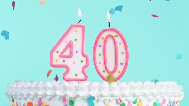 Birthday Cake With Burning Colorful Candles with Number 40 on Pastel Background. Falling confetti. Super Slow Motion, 1000 FPS.