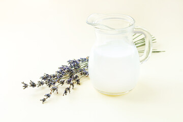 Yogurt or sour milk in jug with lavender flowers