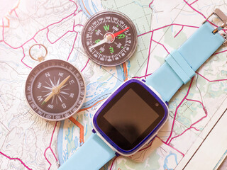 Children's smart watch and two compasses on the map