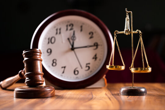 Concept showing of Problems with legal system, delay or slow in judicial justice system by using judge hammer, balance scale and wall clock.
