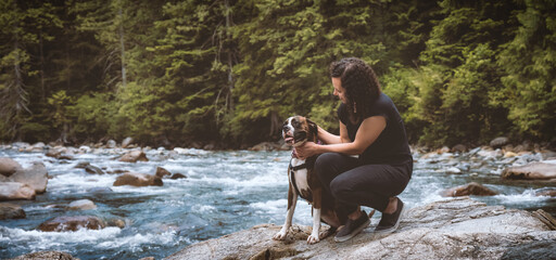 White Caucasian Adult Woman hiking with Boxer Dog in the Canadian Nature. Golden Ears Provincial Park, Maple Ridge, Greater Vancouver, British Columbia, Canada.