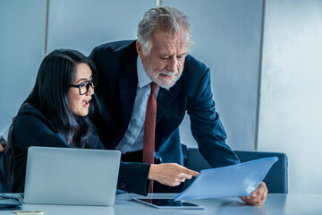Senior executive manager and young businesswoman working in meeting room in the office. The woman...