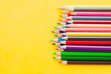 Colorful color pencils isolated on yellow background, art, step for drawing, stationary, set of color pencils and happiness style.