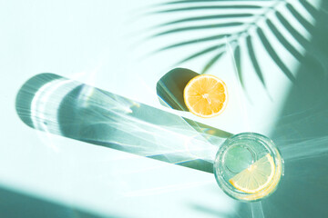 Cool summer drinks - lemonade or soda in glass on blue color background with palm tree leaf shadows © shapovalphoto