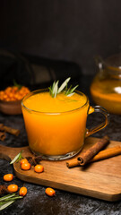Warming sea buckthorn tea with spices on the table. Image with selective focus