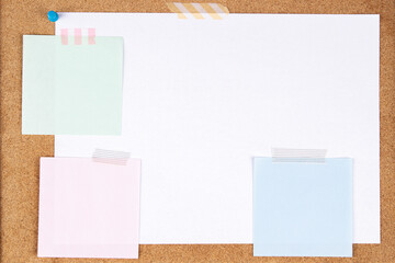 Blank white paper page and note sticks attached with adhesive tape on cork board background