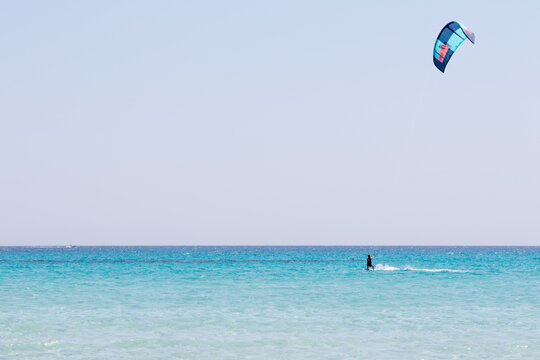 July 23, 2021: boy practicing kitesurfing in the crystal sea near the beach of La Cinta, Sardinia