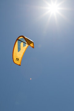 July 23, 2021: Sunbeams illuminate the kitesurf sail near the beach of La Cinta, Sardinia.