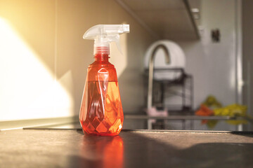 Spray bottle with water on kitchen table top, concept of kitchen cleaning
