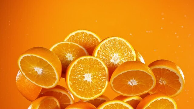 Super slow motion of fresh oranges with water splash flying in the air. Filmed on high speed cinema camera, 1000 fps.