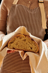 Baker holding loaf of homemade bread