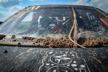 The detail of the dirty veteran rallycross car with mud and dirt on the windscreen. 