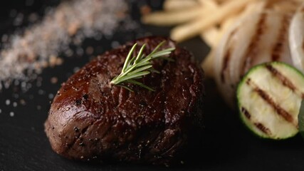 tenderloin steak on black stone plate with french fries