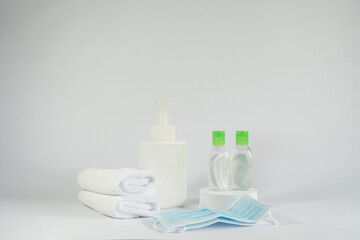 White towels, soap, two bottles of hand sanitiser and surgical masks. the necessary items to protect yourself from the covid-19 virus during this pandemic.