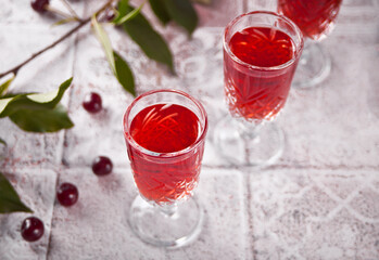 glasses of cherry brandy liqueur with ripe berries
