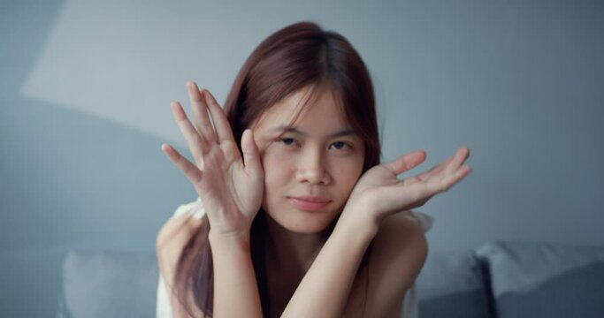 Happy youth Asia teenager girl with funny moment make funny crazy silly face looking at camera in living room at house. Isolate activity lifestyle, Social distance coronavirus pandemic concept.