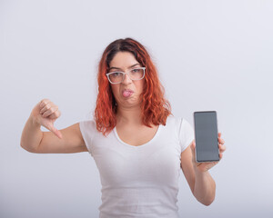Fototapeta premium Caucasian woman holding smartphone with black screen and showing thumb down.