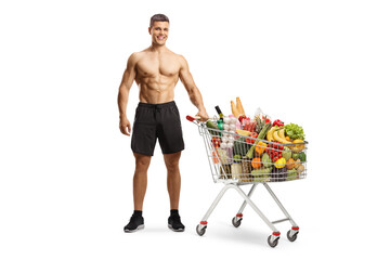 Shirtless muscular man with a shopping cart full of food